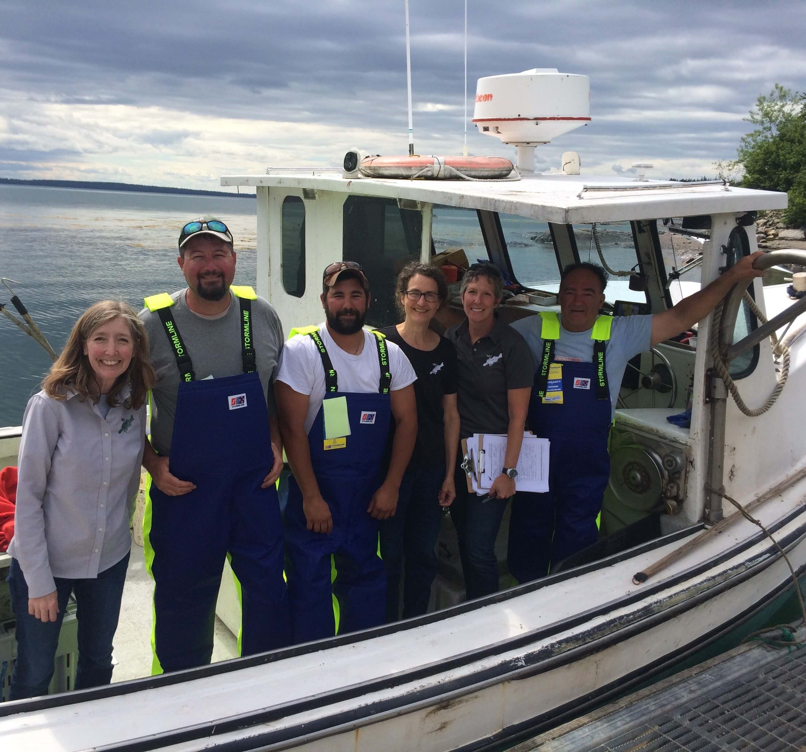 Julie Sorensen & NYCAMH/NEC team stand with fishermen in Seal Cove, ME