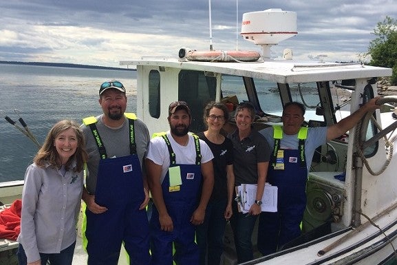 Julie Sorensen & NYCAMH/NEC team stand with fishermen in Seal Cove, ME