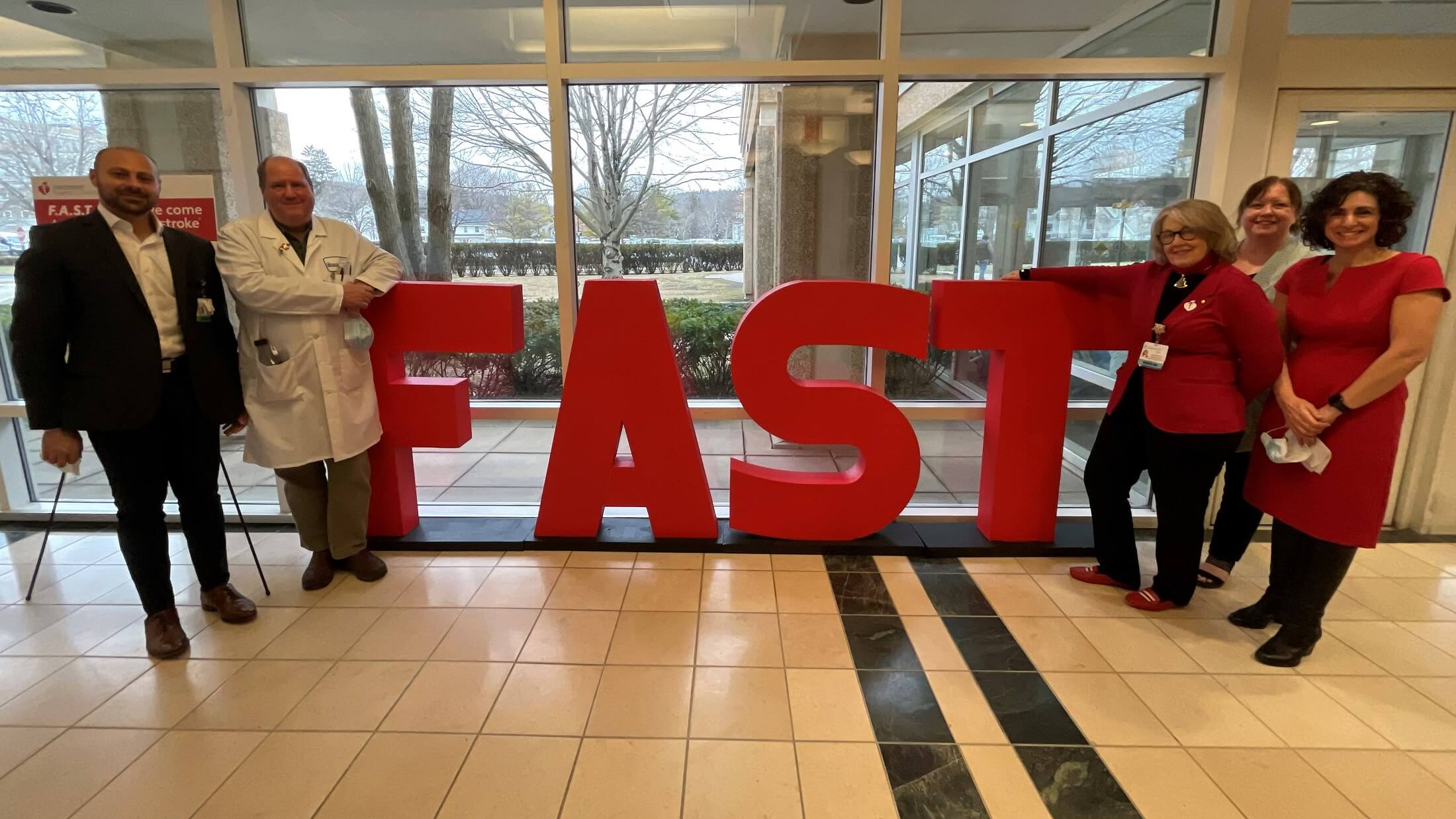 Bassett leaders with Christine Kisiel from American Heart Association of the Greater Utica Area standing in front of life-sized FAST letters