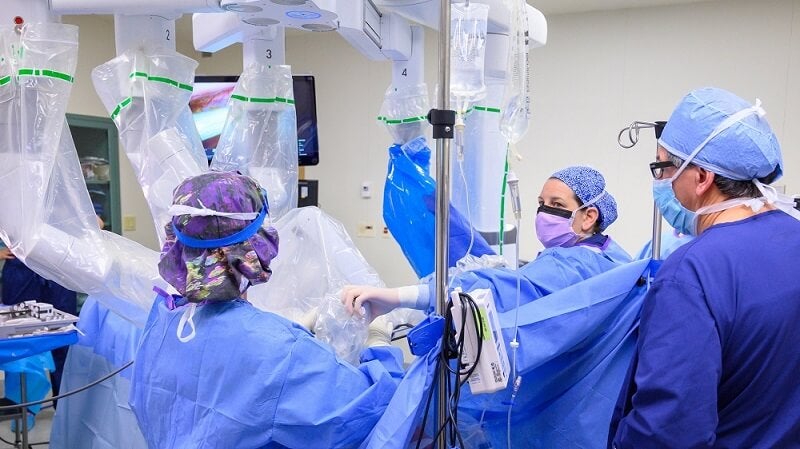 Dr. Luis Oceguera's surgical team oversees the da Vinci robot as he operates the arms using 3D vision technology