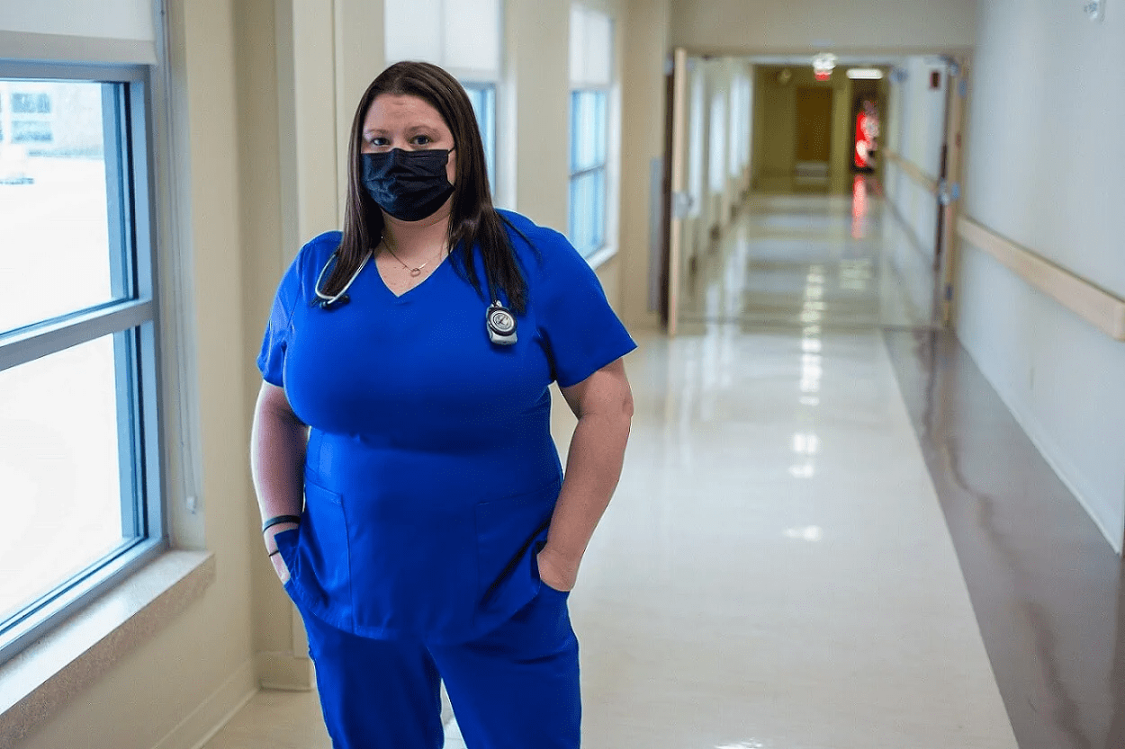 A nurse in mask standing in a hallway