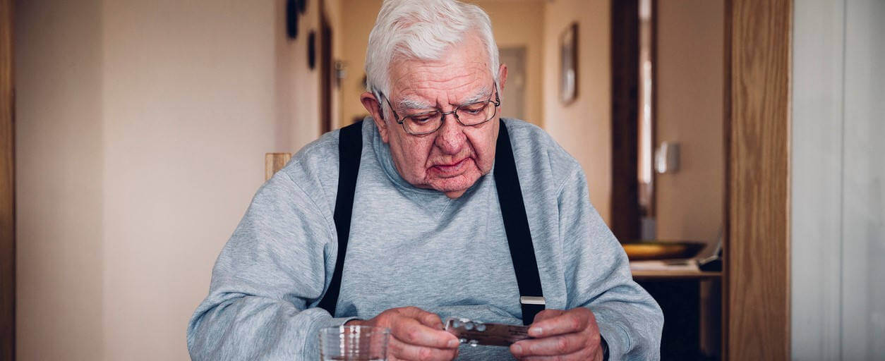 Elderly man sorting out his medication