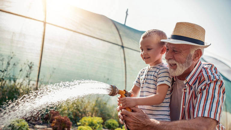 Old man gardening with grandson