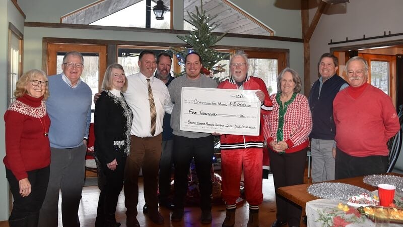 Members of the Lucky Duck Foundation present a ceremonial check to representatives of Bassett Cancer Institute and Cooperstown Food Pantry at a holiday celebration