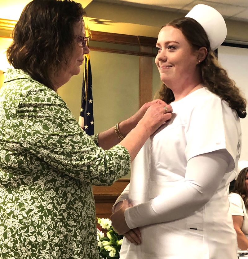 Audrey Gilmore, LPN Class President, is pinned by her mother, Linda Gilmore, RN, during the pinning ceremony. 