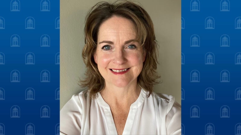 A woman with shoulder length hair is photographed. She is smiling for the camera. 