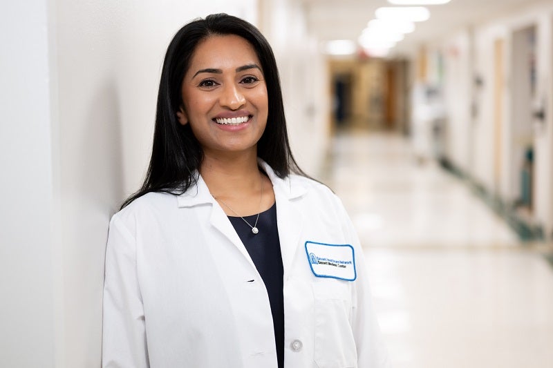 Jeena Easow, MD standing in a hallway smiling at the camera