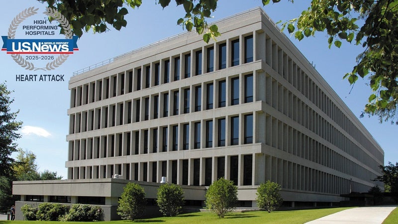 U.S. News & World Report High Performing Hospital Seal for 2025-2026 for the Treatment of Heart Attack is seen over an image of a building on the Bassett Medical Center campus.