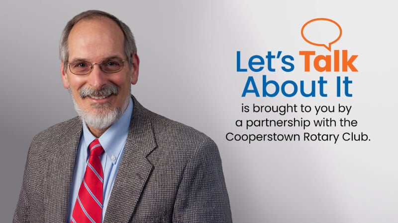 A man, Dr. Chris Kjolhede, is photographed wearing a suit and tie. Text next to his photo reads "Let's Talk About It is brought to you by a partnership with the Cooperstown Rotary Club" 