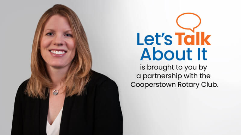 A woman, Amanda Winans, is photographed in professional attire. Text next to his photo reads "Let's Talk About It is brought to you by a partnership with the Cooperstown Rotary Club"