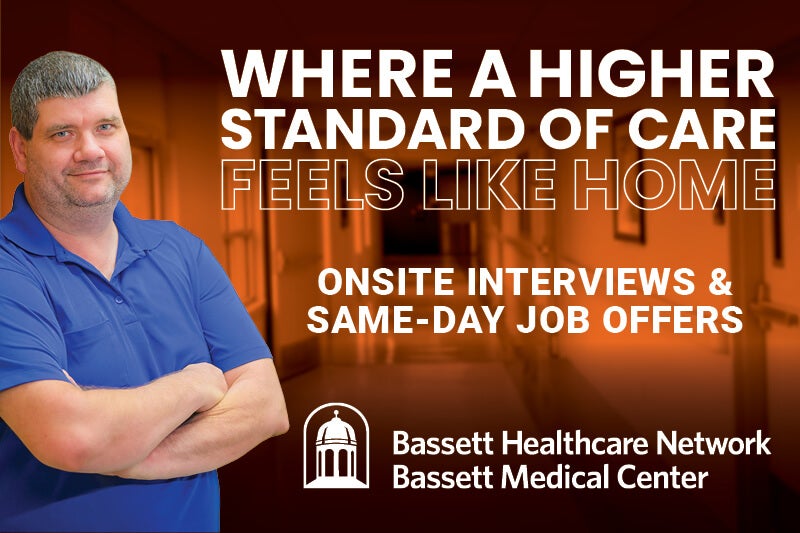 A Bassett Food Service Worker Leaning Against an Orange Clinical Backgruond with the Heading: "Where a Higher Standard of Care Feels Like Home" and Subheading: "Onsite Interviews & Same-Day Job Offers" and Bassett Medical Center logo shown