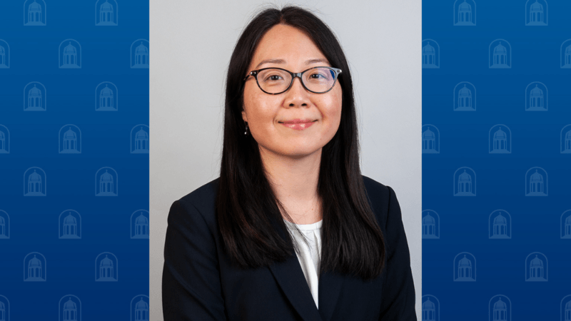 A woman, Dr. Joon Shim, is photographed. She is wearing glasses and professional attire. 
