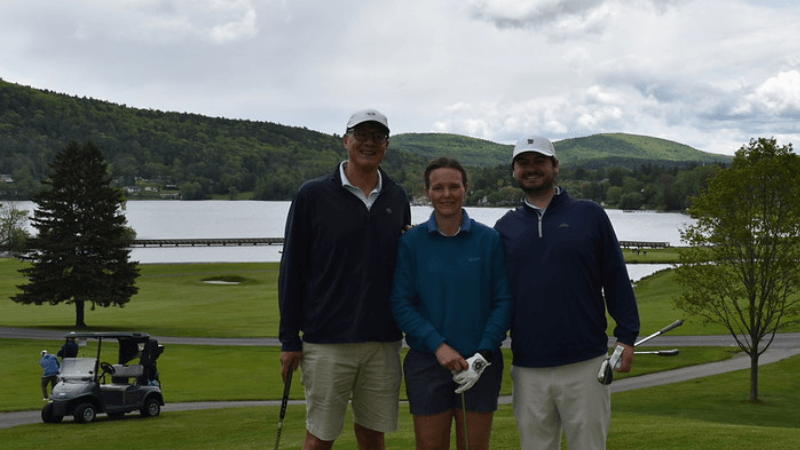 Three golfers stand together on The Otesaga Hotel’s Leatherstocking Golf Course.