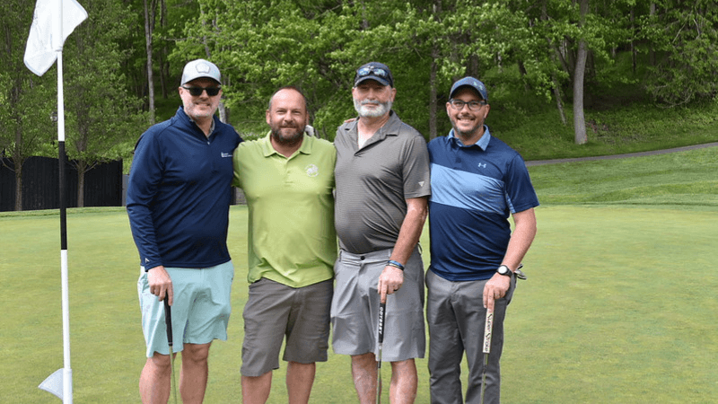Four golfers stand together on The Otesaga Hotel’s Leatherstocking Golf Course.