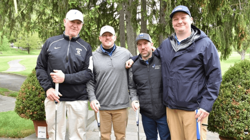Four golfers stand together on The Otesaga Hotel’s Leatherstocking Golf Course.