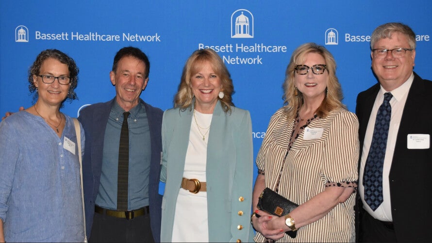Five people stand side by side in front of a Bassett Healthcare Network backdrop.