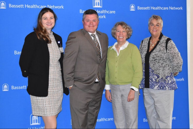Four people stand side by side in front of a Bassett Healthcare Network backdrop.