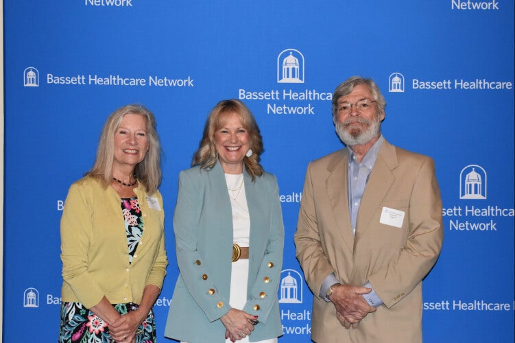  Three people stand side by side in front of a Bassett Healthcare Network backdrop.