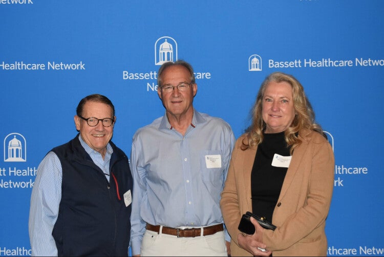Three people stand side by side in front of a Bassett Healthcare Network backdrop.