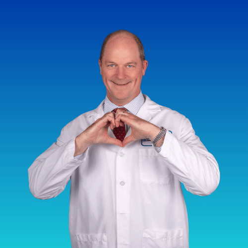 Doctor in white coat making heart shape with hands