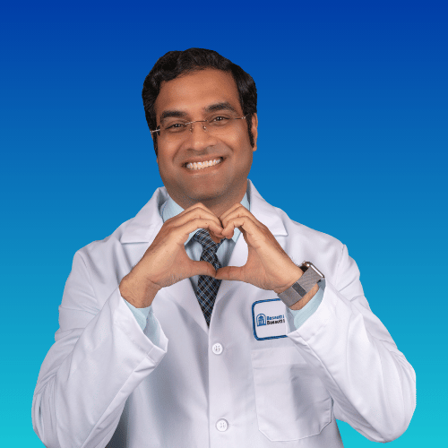 Doctor in white coat making heart shape with hands