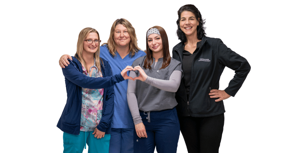 Nursing and administrative staff standing together and making heart shapes with hands