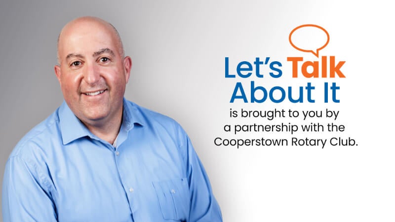 Graphic includes an image of a man in professional attire. Next to the photo is text that reads "Let's Talk About It is brought to you by a partnership with the Cooperstown Rotary Club" 