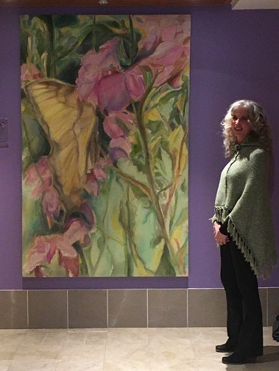 Elizabeth Bryan-Jacobs standing in front of donated painting