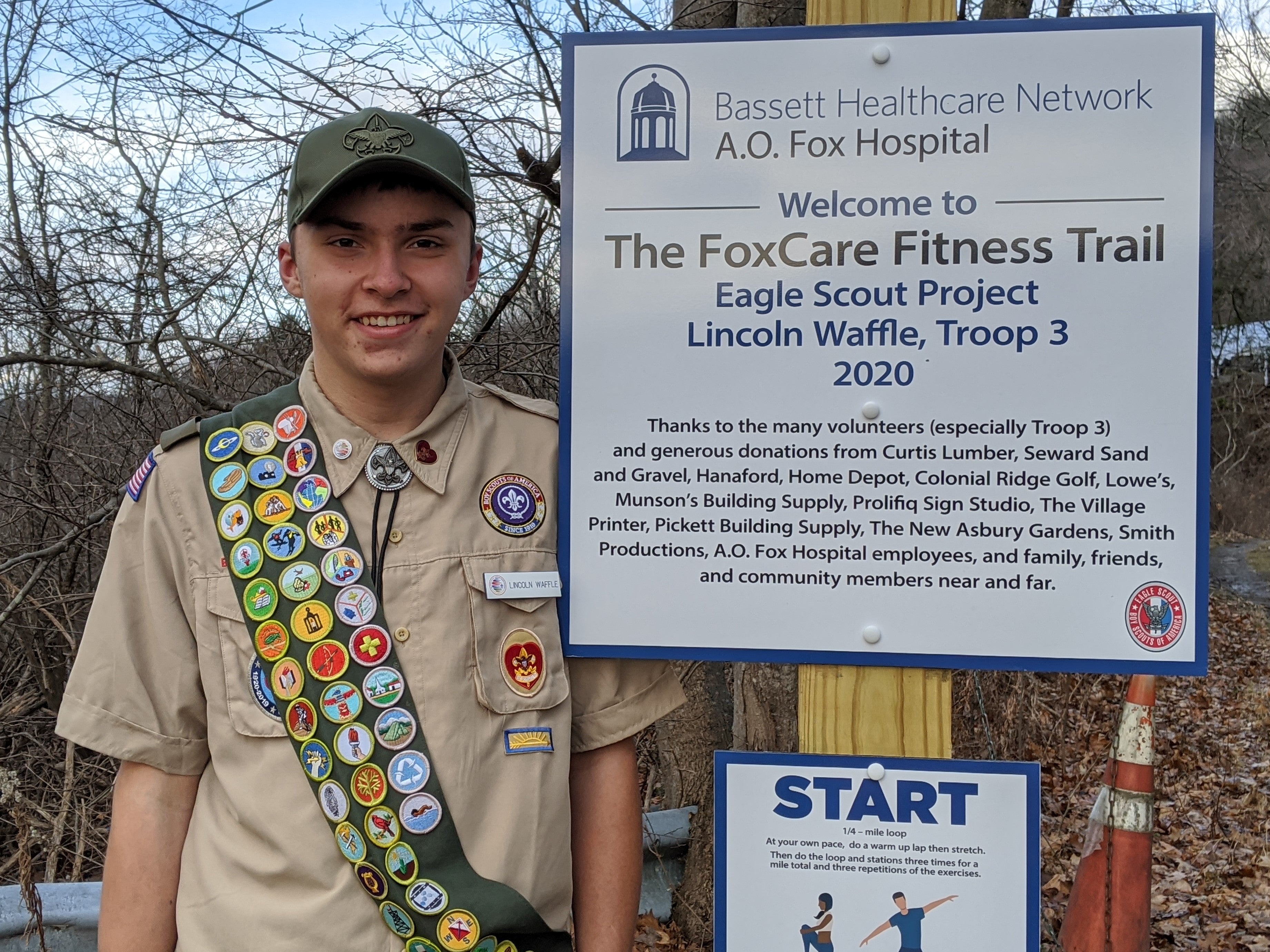 Lincoln Waffle, local Eagle Scout, stands at the entrance of FoxCare Center’s new public fitness trail in November.