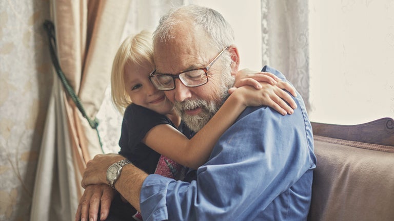 grandfather hugging granddaughter