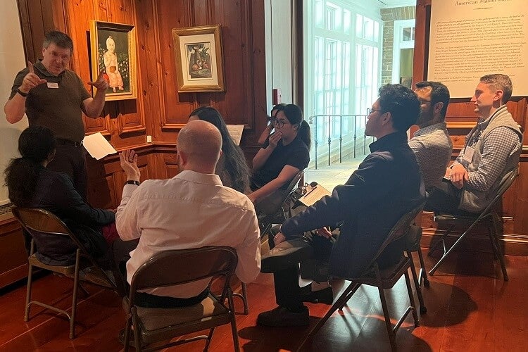 Kevin Gray guides a group of internal medicine and transitional residents through sharing their observations of “Seated Girl with Strawberries,” an American folk-art painting by Joshua Johnson.
