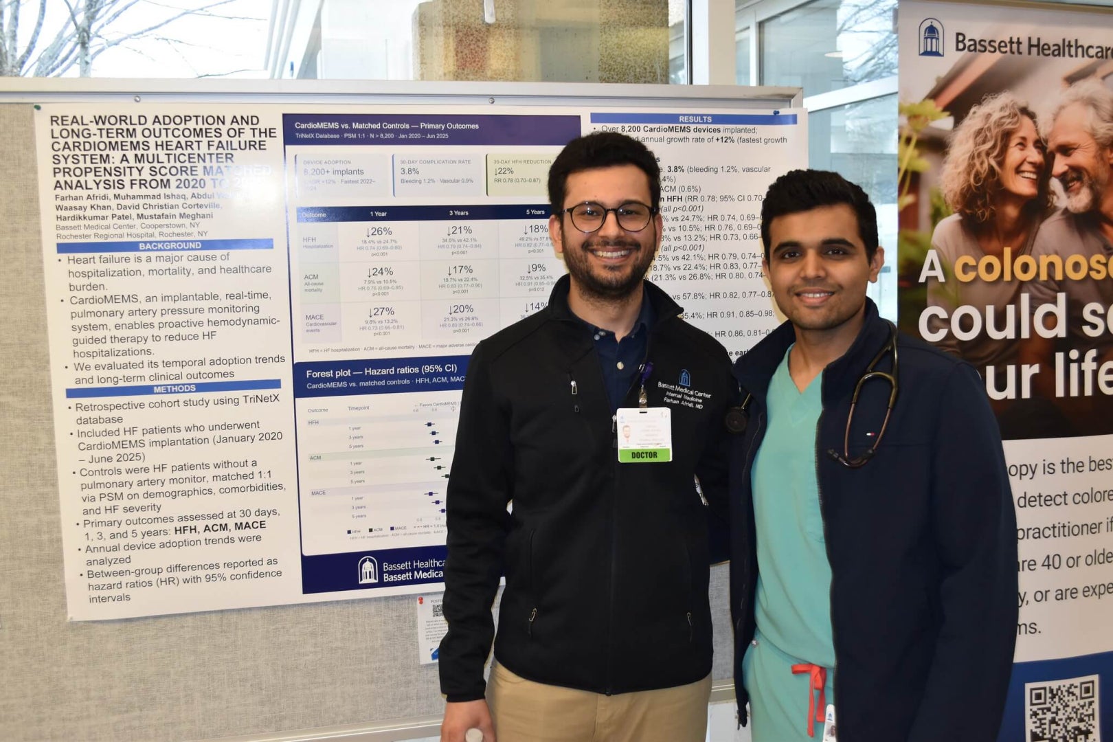 Two men stand next to a poster showcasing their research related to heart health.