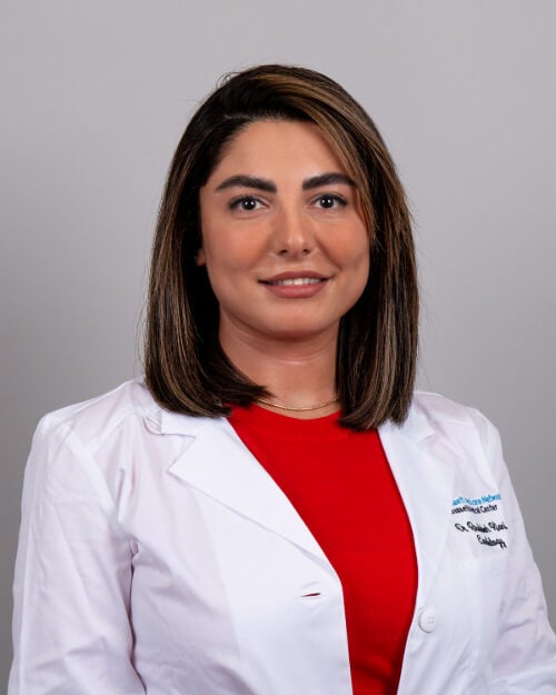 Dr. Roudy Kiani is photographed wearing a white coat and red outfit.