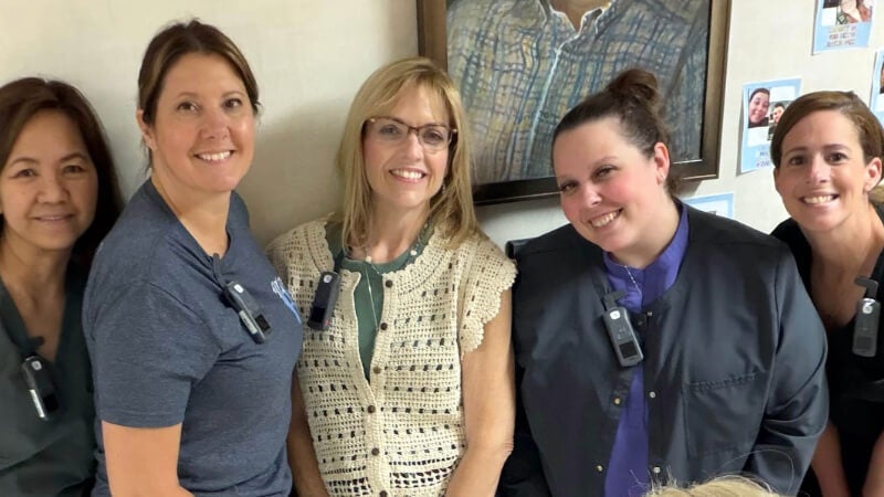 Five caregivers are photographed. They are wearing Vocera Smartbadge devices.