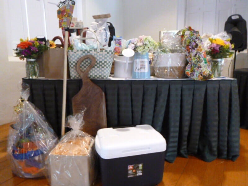Items donated for the basket raffle held at the Bassett Cancer Institute’s Annual National Cancer Survivors Day Luncheon are displayed on a table.